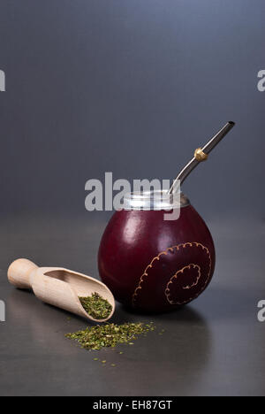 Kalebasse und Bombilla mit Yerba Mate auf grauem Hintergrund Stockfoto