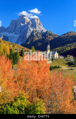 Rot und orange Bäume vor der kleinen Kirche von Selva di Cadore, mit Monte Pelmo im Hintergrund, Veneto, Italien Stockfoto