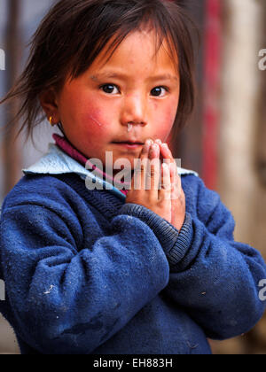 Junges Mädchen in Lo Manthang, Mustang, Nepal legt ihre Hände in die Position "Namaste". Konzentrieren Sie sich auf Händen. Stockfoto