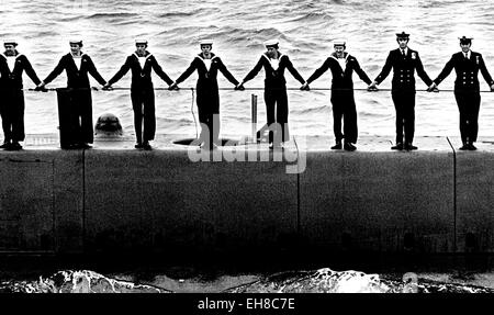 AJAXNETPHOTO. 28. JUNI 1977. SPITHEAD, ENGLAND. -HAND IN HAND - DIE BESATZUNG DES U-BOOT HMS SEELÖWE-LINK-HÄNDE AUF DEM DECK DES SCHIFFES ALS HM DIE KÖNIGIN BEGANN HMRY BRITANNIA, BEWERTUNGEN DIE SILVER JUBILEE-FLOTTE IN SPITHEAD AM 28. JUNI 1977.  FOTO: JONATHAN EASTLAND/AJAX. REF: HDD SSJUB 77 Stockfoto