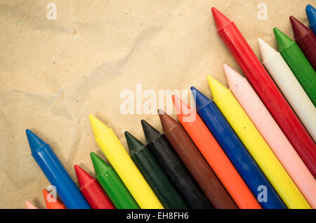 Satz von aufgereiht farbigen Wachs, die Buntstifte auf einem natürlichen Recycling-Papier-Hintergrund hautnah Stockfoto