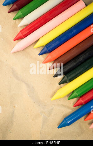 Satz von aufgereiht farbigen Wachs, die Buntstifte auf einem natürlichen Recycling-Papier-Hintergrund hautnah Stockfoto