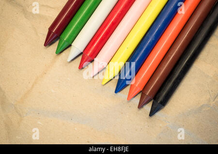 Satz von aufgereiht farbigen Wachs, die Buntstifte auf einem natürlichen Recycling-Papier-Hintergrund hautnah Stockfoto