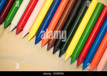 Satz von aufgereiht farbigen Wachs, die Buntstifte auf einem natürlichen Recycling-Papier-Hintergrund hautnah Stockfoto