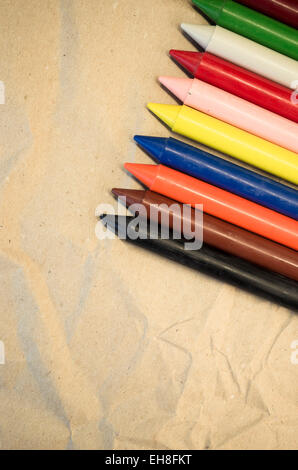 Satz von aufgereiht farbigen Wachs, die Buntstifte auf einem natürlichen Recycling-Papier-Hintergrund hautnah Stockfoto