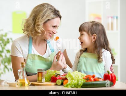 Kind füttern Mutter Gemüse in der Küche Stockfoto