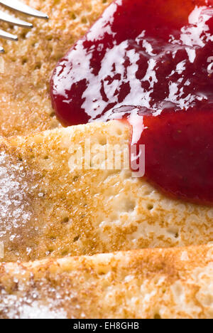 Dünne Pfannkuchen mit Erdbeer-Marmelade und Zucker. Stockfoto