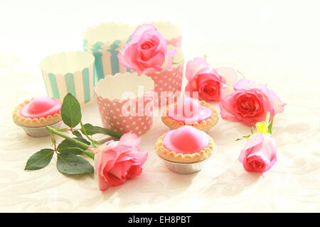 Rosa Kuchen auf blaue Platte mit rosa Rosen Stockfoto