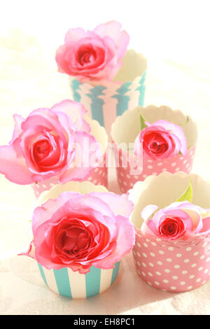 Rosa Rosen in Muffinförmchen, Stillleben Stockfoto