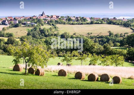 Feld mit Weizen-Stroh-Ballen und Dorf in der Region Dordogne, Frankreich, Europa Stockfoto