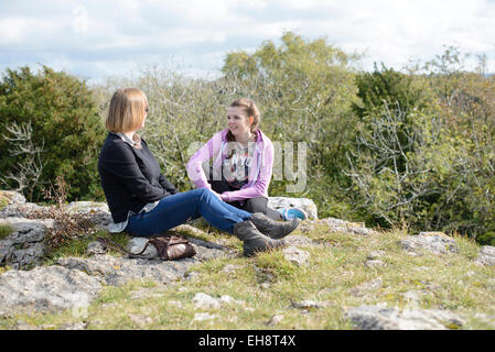 Mutter und Tochter im Teenageralter in der Landschaft chatten Stockfoto