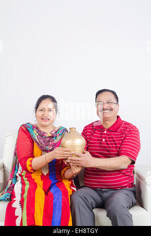 2 indische Senioren verheiratet Paare sitzen Sofa Sparschwein sparen Geld Stockfoto