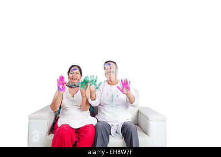 2 indische Senioren verheiratet Paare Holi Festival sitzen Sofa hand zeigen Stockfoto