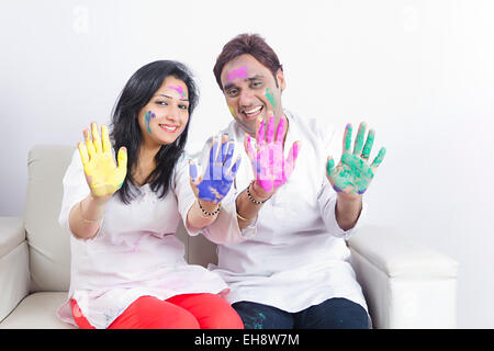 2 indische Ehepaare Holi Festival sitzen Sofa hand zeigen Stockfoto