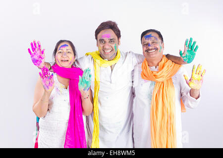 3 indische Erwachsene Eltern und Sohn Holi Festival hand zeigen Stockfoto