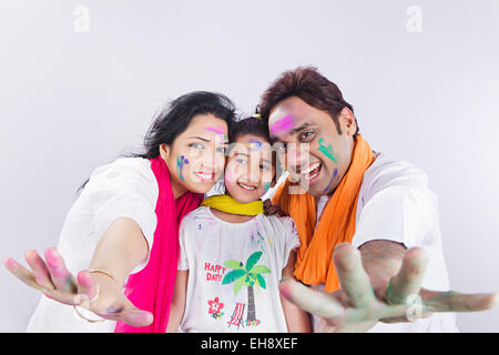 3 indischer Eltern und Kind Tochter Holi Festiva genießen Hand zeigen Stockfoto