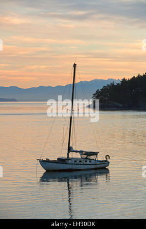Ein Segelboot ist sicher im Hafen von Bowman Bay auf Whidbey Island bei Sonnenuntergang. Stockfoto