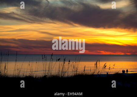 Menschen am Okaloosa Strand bei Sonnenuntergang spazieren. Stockfoto