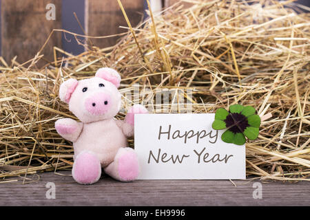 Glücksschwein mit Kleeblatt und Karte mit englischem Text Happy New Year Stockfoto