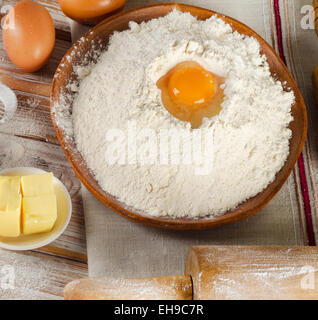 Backzutaten - Eiern, Mehl, butter auf einem weißen Hintergrund Holz Stockfoto