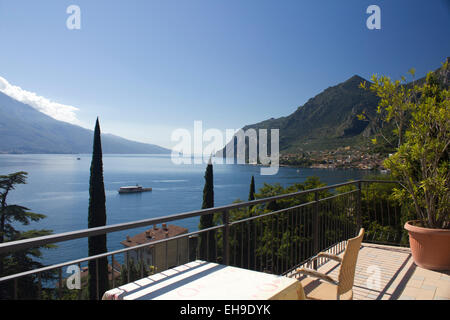 Terrasse mit Blick auf einen See. Blick von einer Terrasse über dem Gardasee mit Bergen in der Ferne. Stockfoto