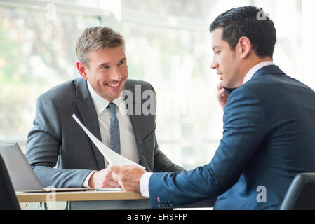 Geschäftsleute, die Dokumente in Sitzung diskutieren Stockfoto