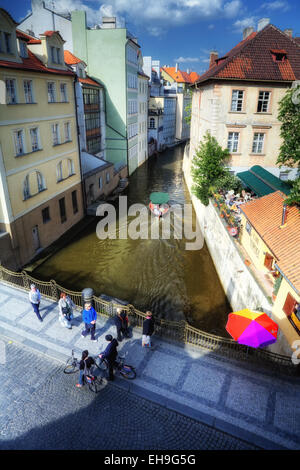 Straßen von Prag mit Touristen auf Fahrrädern und Sportboote am Kanal Stockfoto