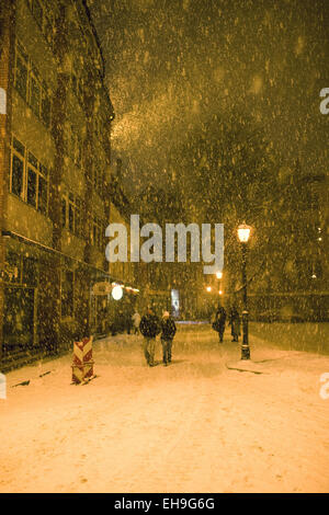 Heftige Schneefälle an einem gelben Straßenlaternen in den Straßen der Altstadt Stockfoto