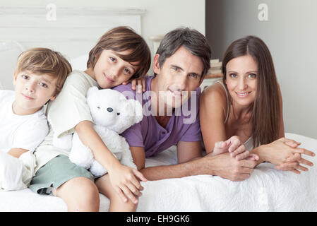 Eltern und jungen Söhne gemeinsam entspannen auf Bett, Porträt Stockfoto