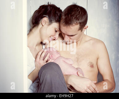 Neue Eltern mit Neugeborenen Baby sitzen Stockfoto