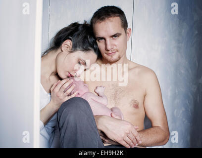 Neue Eltern mit Neugeborenen Baby sitzen Stockfoto