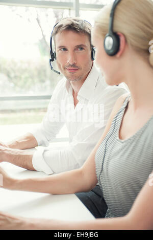 Call-Center-Arbeiterinnen im Chat zwischen den anrufen Stockfoto