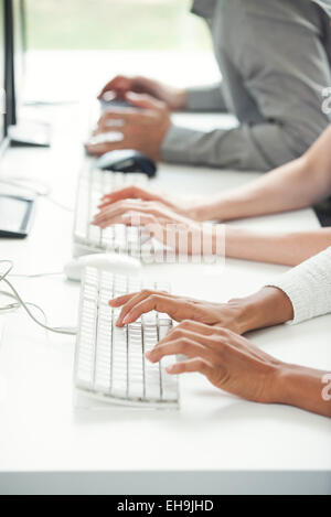 Büroangestellte mit Computertastaturen Stockfoto