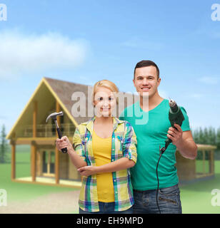 lächelnde paar mit Hammer und Bohrer Stockfoto