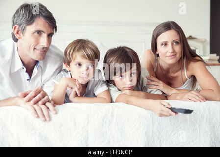 Familie vor dem Fernseher am Bett, Porträt Stockfoto
