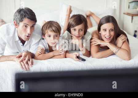 Familie vor dem Fernseher am Bett, Porträt Stockfoto