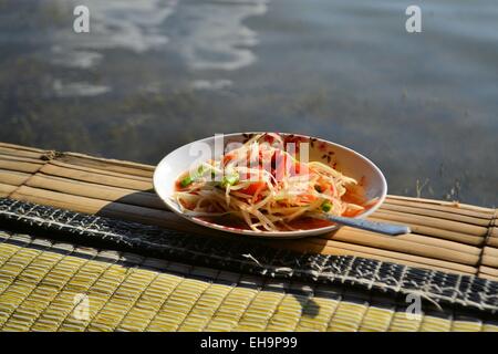 Thai Green Papaya Salat SOM TAM in Bambushütte über Wasser Stockfoto