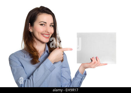 Positiven lächelnde Frau im blauen Hemd zeigt auf leeres Blatt Papier textfreiraum isoliert auf weißem Hintergrund Stockfoto