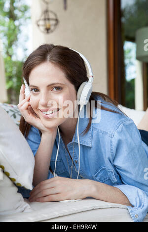 Junge Frau, zuhören, Kopfhörer, Porträt Stockfoto