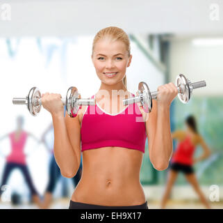 lächelnde Frau heben Stahl Hanteln Stockfoto