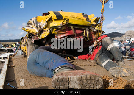 zwei Mechaniker arbeiten auf ein altes Auto auf die Demolition Derby nach einem Absturz Stockfoto