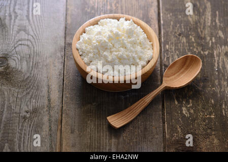 Quark in einer Holzschale auf dunklem Untergrund aus Holz Stockfoto