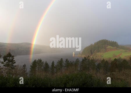 Erhöhten Aussicht eines Regenbogens bilden über Lake Vyrnwy, mit dem gotischen gestaltete Straining Turm im Hintergrund. Stockfoto