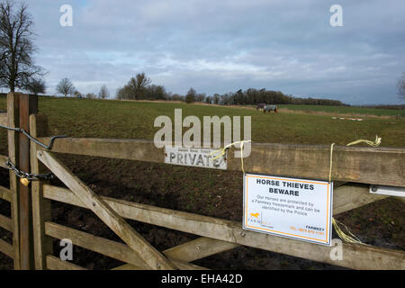 Ein Schild warnt Pferdediebe, dass diese Pferde durch die Farmkey Freezemark, Cotswolds, Gloucestershire, UK geschützt sind. Stockfoto