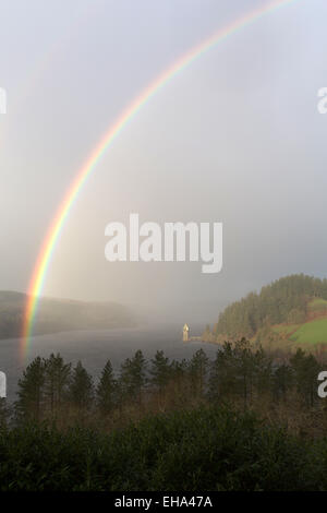 Erhöhten Aussicht eines Regenbogens bilden über Lake Vyrnwy, mit dem gotischen gestaltete Straining Turm im Hintergrund. Stockfoto