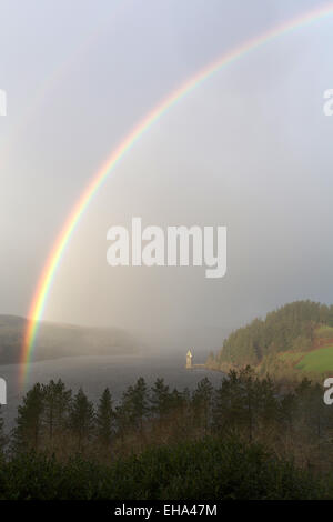 Erhöhten Aussicht eines Regenbogens bilden über Lake Vyrnwy, mit dem gotischen gestaltete Straining Turm im Hintergrund. Stockfoto