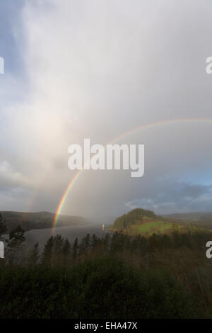 Erhöhten Aussicht eines Regenbogens bilden über Lake Vyrnwy, mit dem gotischen gestaltete Straining Turm im Hintergrund. Stockfoto