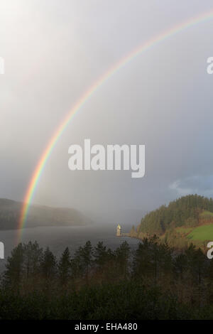 Erhöhten Aussicht eines Regenbogens bilden über Lake Vyrnwy, mit dem gotischen gestaltete Straining Turm im Hintergrund. Stockfoto