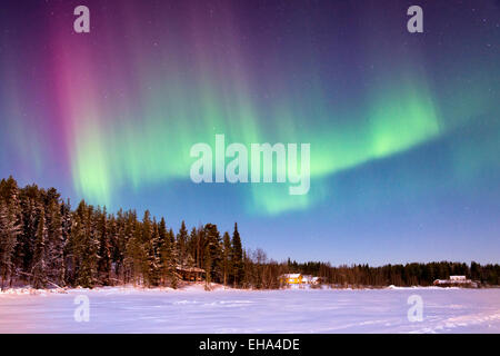 Die Aurora Borealis oder Nordlichter am Nachthimmel über einen gefrorenen See bei Levi Lapland Finland Stockfoto