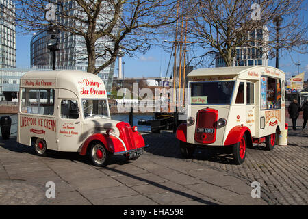 „Ford Thames“ und Commer Van sind klassische Autos, geschätzte Veteranen, restaurierte alte Zeitmesser, Sammlermotoren, Vintage-Tradition, und alte, erhaltene, Sammlerfahrzeuge, die von einem Milcheisverkäufer in der hellen Frühlingssonne in Liverpool verwendet werden, während sich die Touristenattraktionen auf einen Zustrom ausländischer Touristen vorbereiten. Stockfoto